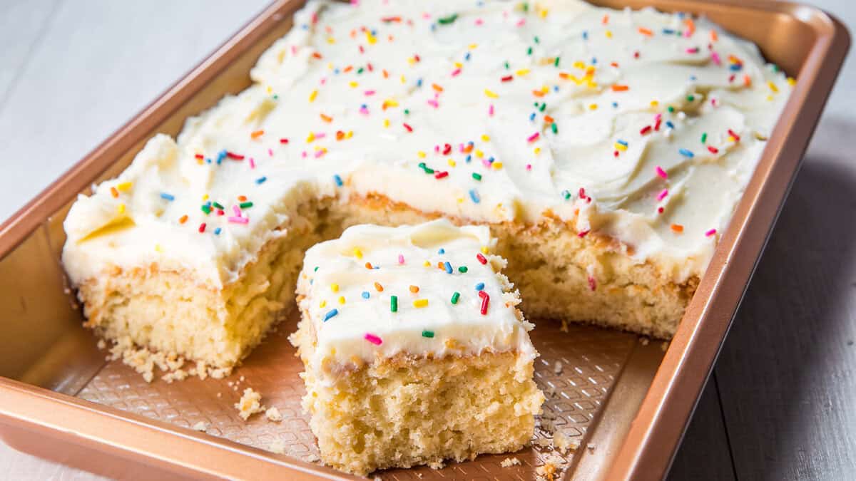 A vanilla cake baking sheet with a slice cut out of it.