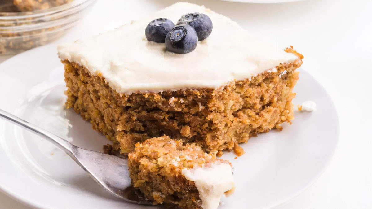 A slice of glazed oatmeal cake, baked until golden, on a plate.