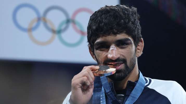 India TV - Aman Sehrawat with the bronze medal after beating Darian Toi Cruz of Puerto Rico