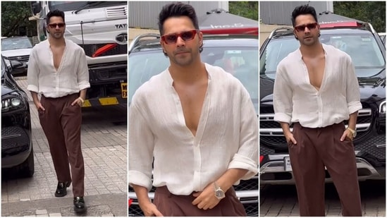 Varun Dhawan sports a laid-back style in his latest look, which includes a smart white open shirt with brown trousers. He completes the ensemble with shiny black shoes, a wristwatch and red-framed sunglasses. (Instagram)