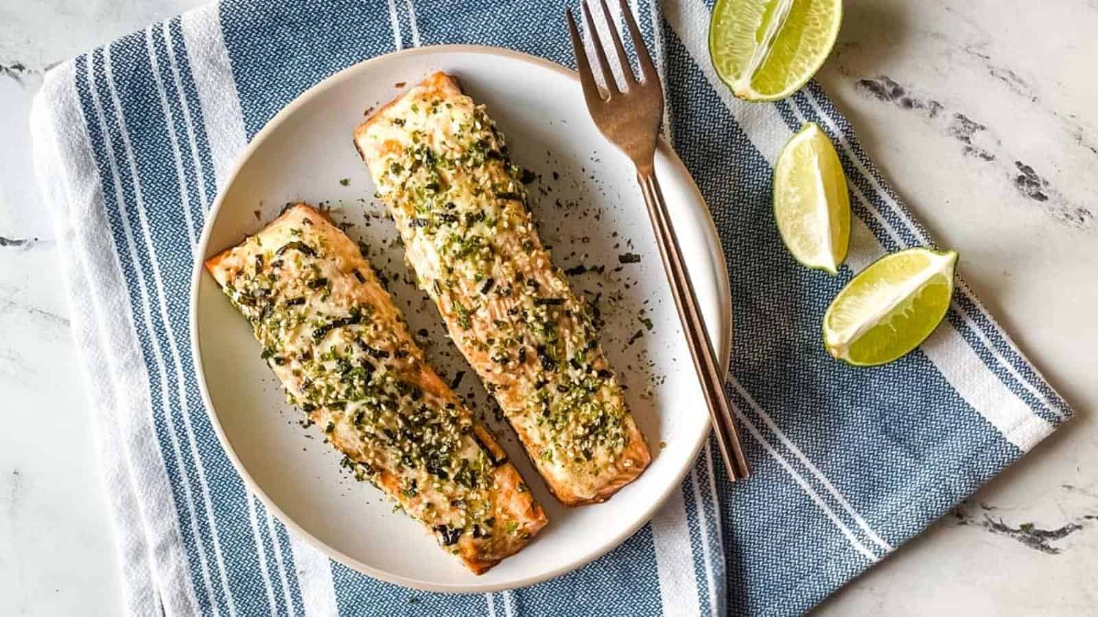 Two furikake salmon fillets on a white plate.