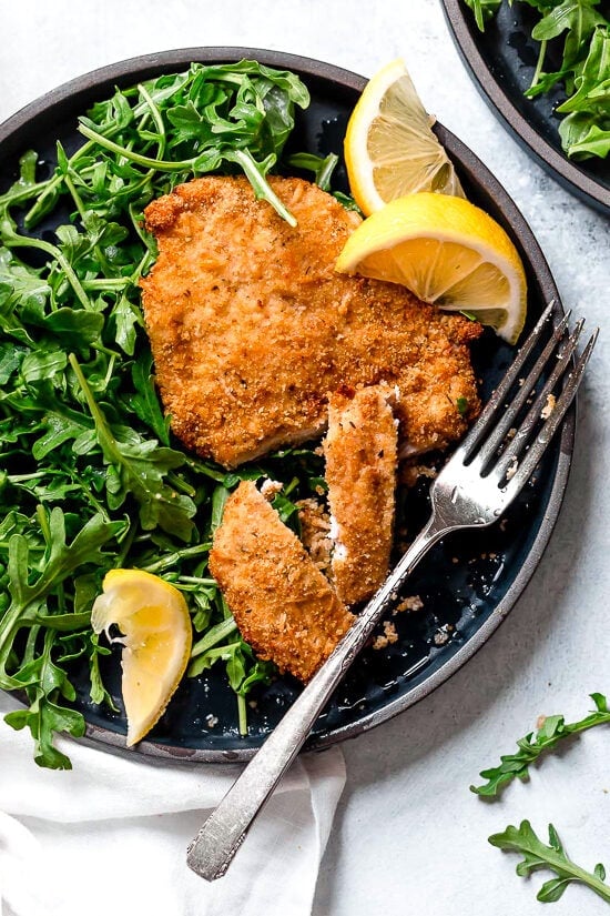 Crispy, golden, and delicious air fryer chicken Milanese with baby arugula and lemon wedges is one of my favorite dinner recipes.