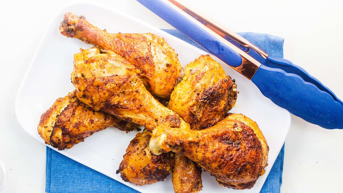 An overhead image of a plate of baked chicken legs.