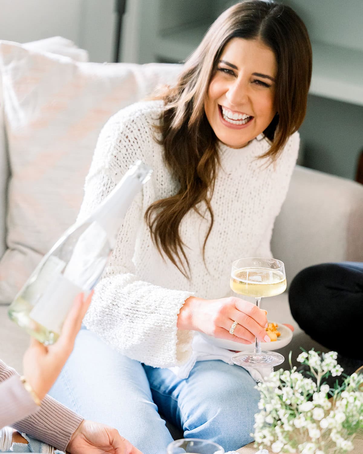 Cookbook author Erin Clarke laughing and holding a glass of champagne