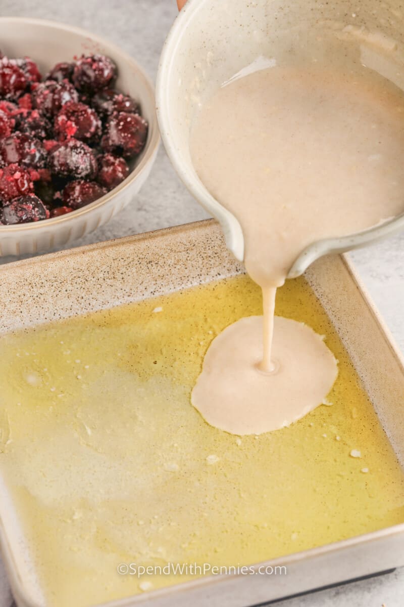 Adding ingredients to the pan to make Cherry Cobbler