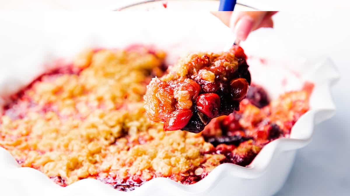 A spoonful of cherry crumble is served.