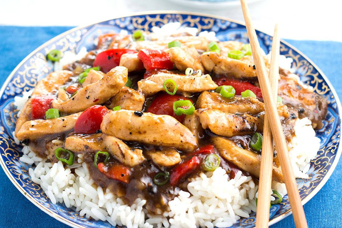 Chicken with black bean sauce piled on a bed of rice