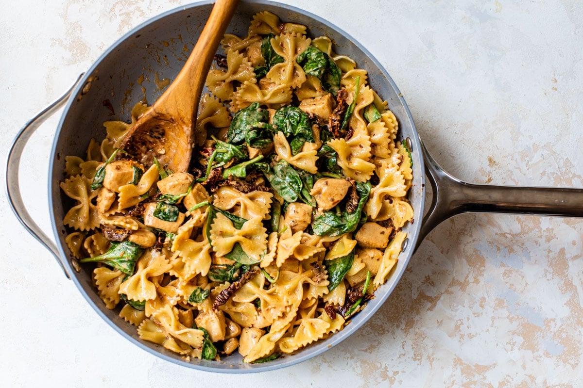 Creamy pasta recipe with chicken and sundried tomatoes in a pan