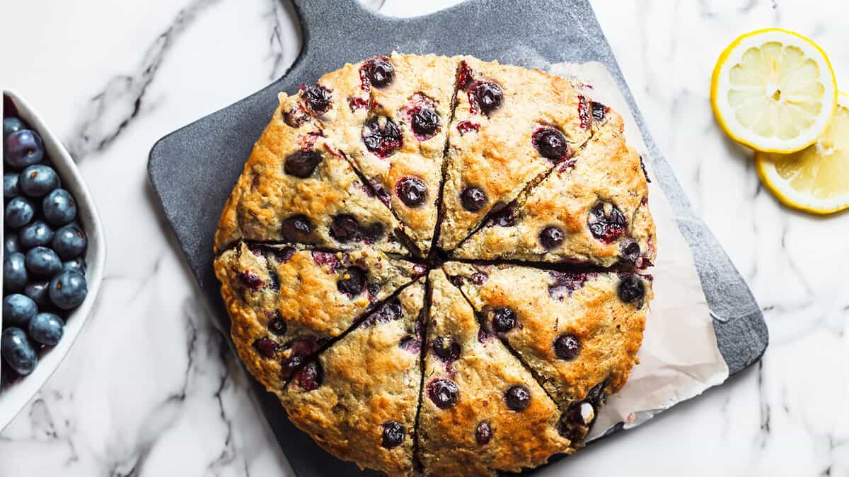 A delicious batch of blueberry scones on a stone cutting board.