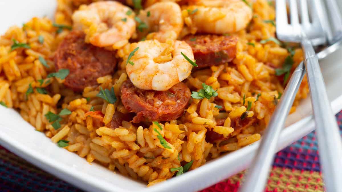 A bright yellow saffron rice dish topped with chorizo ​​and shrimp.