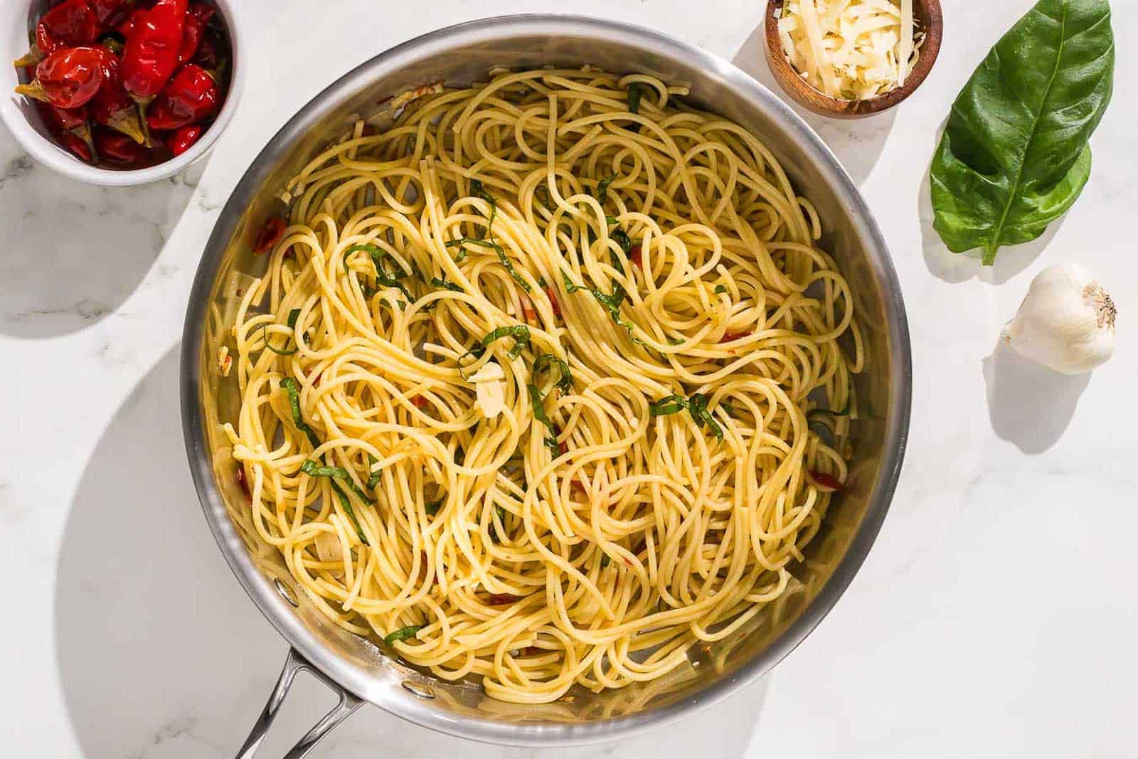 The pasta with garlic, oil and chili is mixed with a black pasta fork.