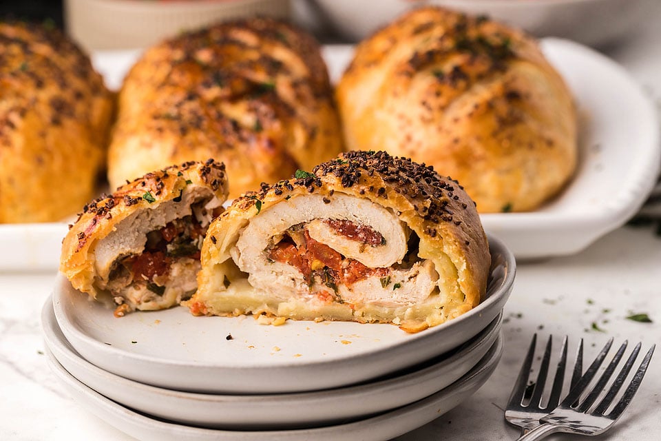 Bruschetta stuffed chicken breasts on a plate.