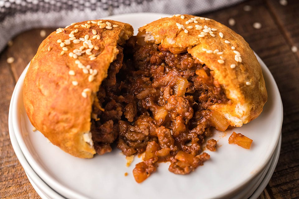 A cookie pocket filled with ground beef on a plate.