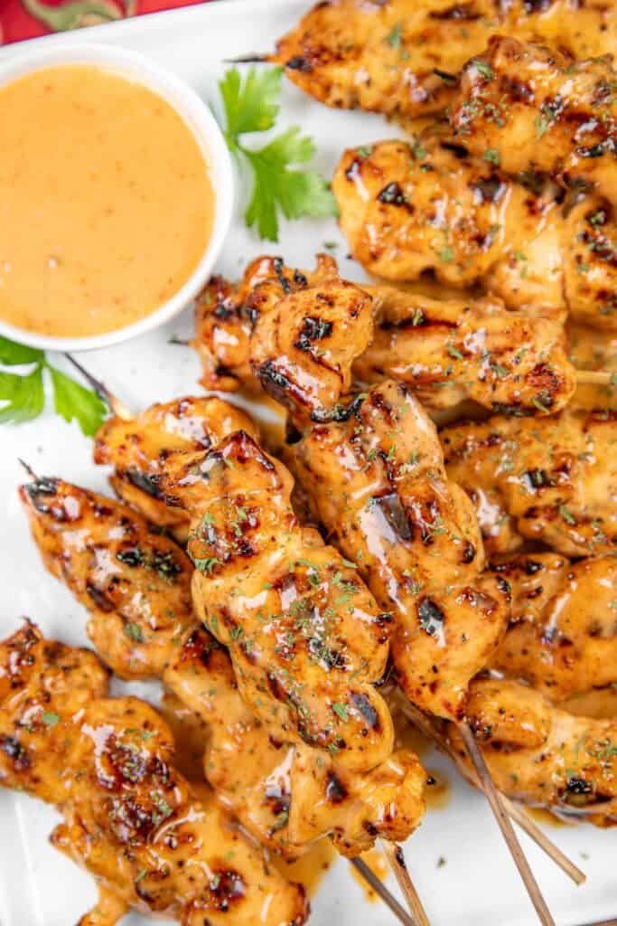 Grilled bang bang chicken skewers on a platter