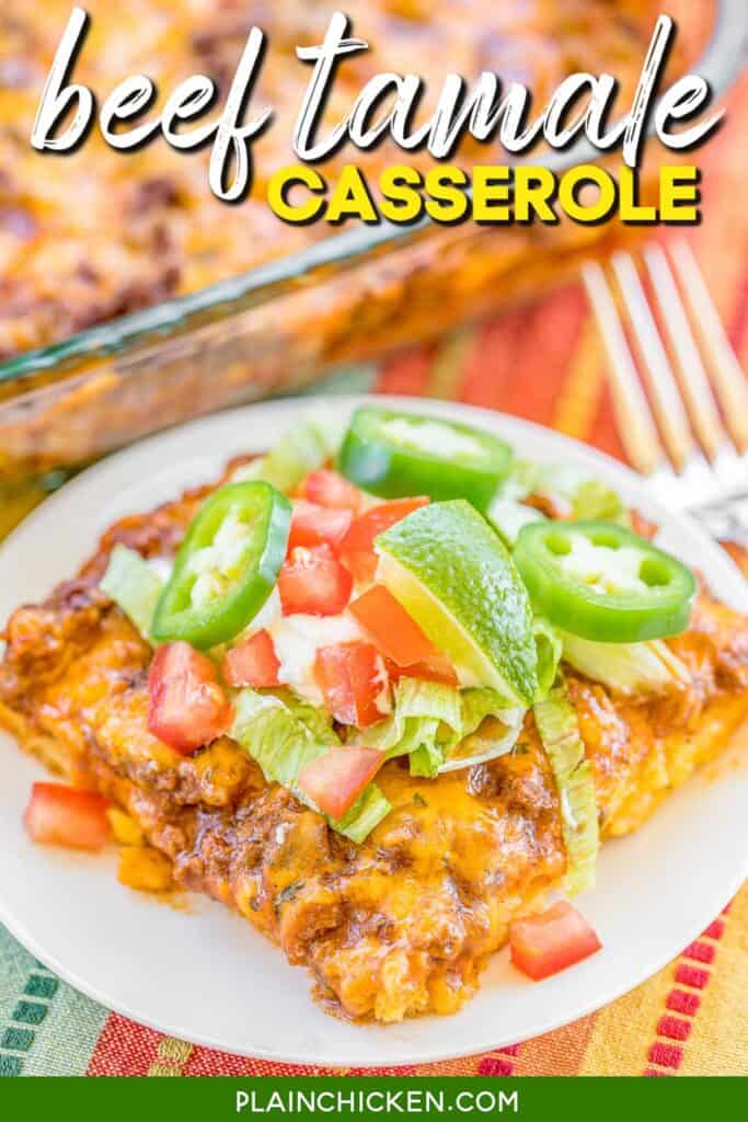 Slice of beef tamale in casserole on a plate topped with lettuce, tomatoes and lemon