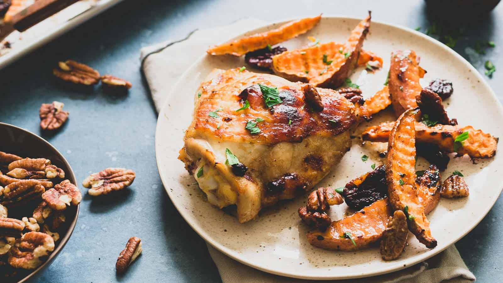 Roasted chicken thighs with sweet potatoes and walnuts.