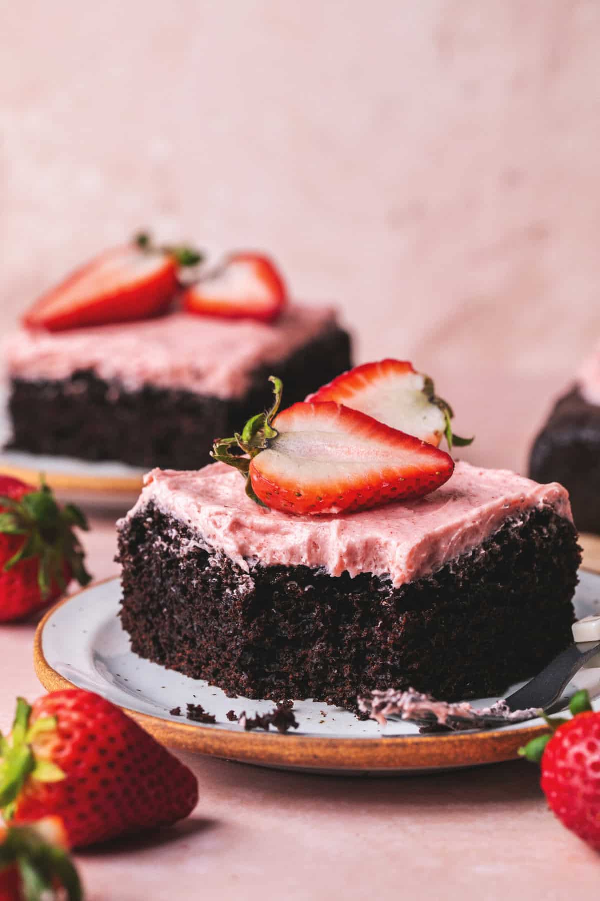 slice of chocolate cake with strawberry frosting and strawberries