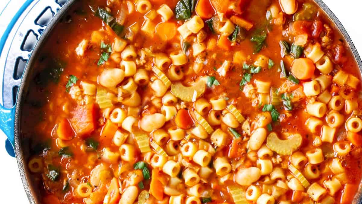 A close up image of pasta fagioli soup in a large pot.