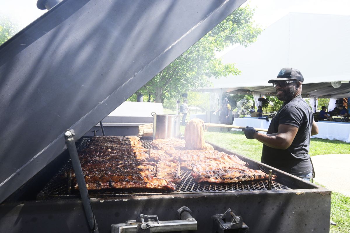 Chef and grillmaster Rodney Scott cleans grilled meats at The Family Reunion presented by Chef Kwame Onwuachi at the Salamander Resort on August 17, 2023 in Middleburg, Virginia.