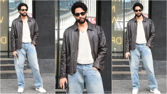 Siddhant Chaturvedi looks dapper in his latest outfit, sporting a basic white V-neck T-shirt paired with light blue baggy jeans and a brown biker jacket. Paired with white sneakers and black sunglasses, he pulls off a cool and effortless look. (HT Photo/VarinderChawla)