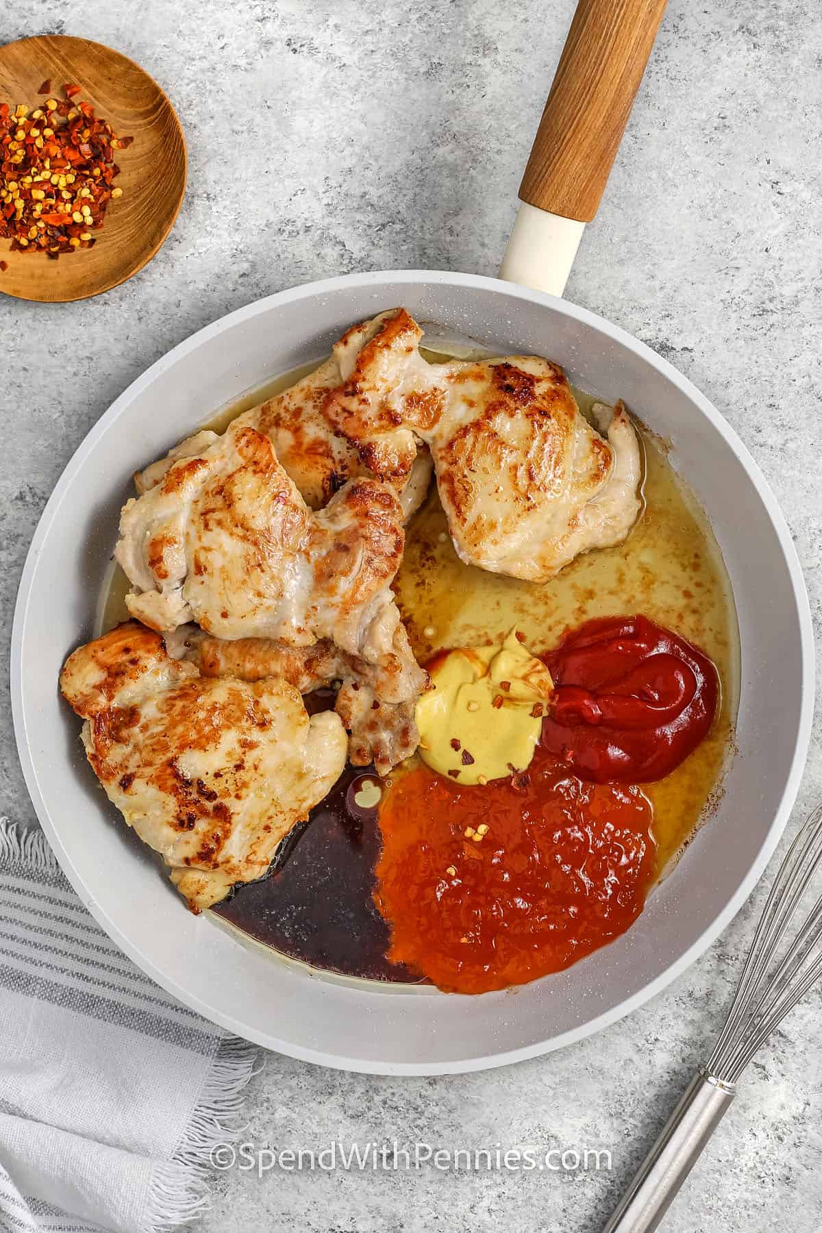 Adding ingredients to cooked chicken to make Apricot Chicken