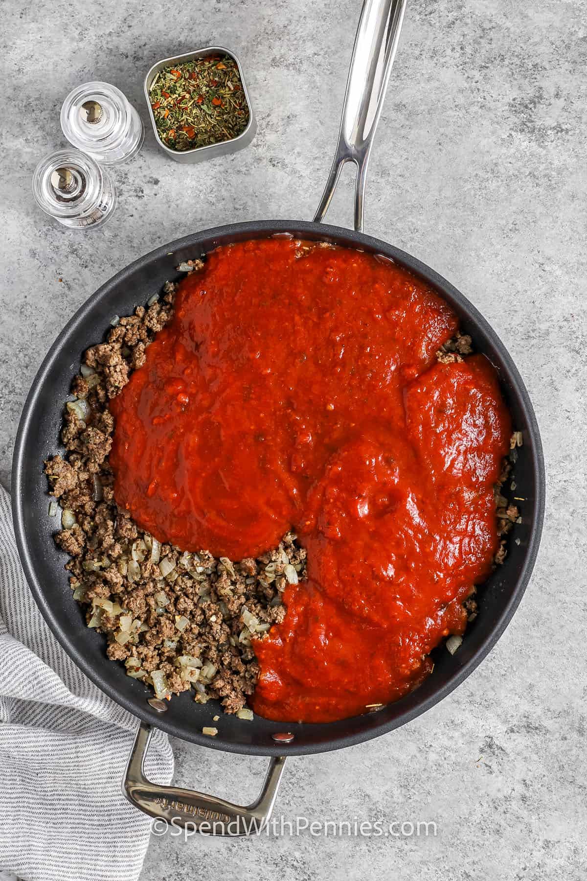 Adding sauce to meat to make baked rigatoni