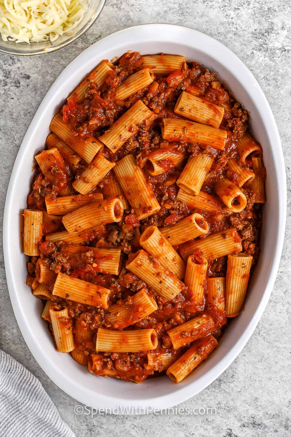 Pasta with sauce in a casserole dish to make baked Rigatoni