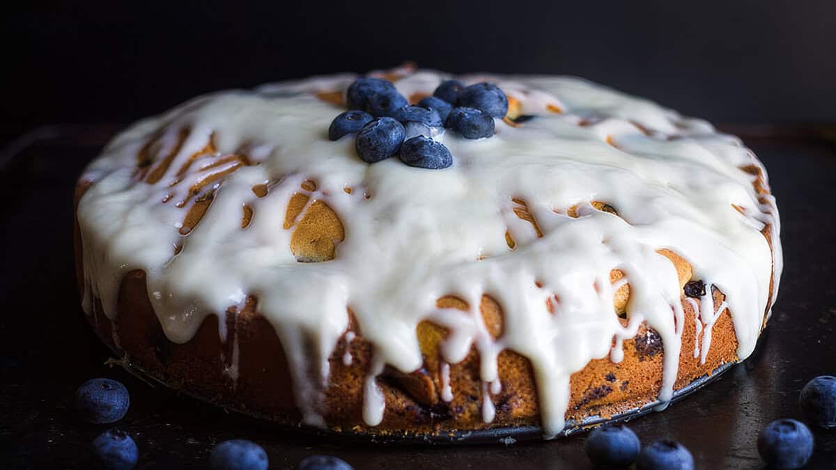 The best blueberry pie ever in a pie plate topped with fresh blueberries