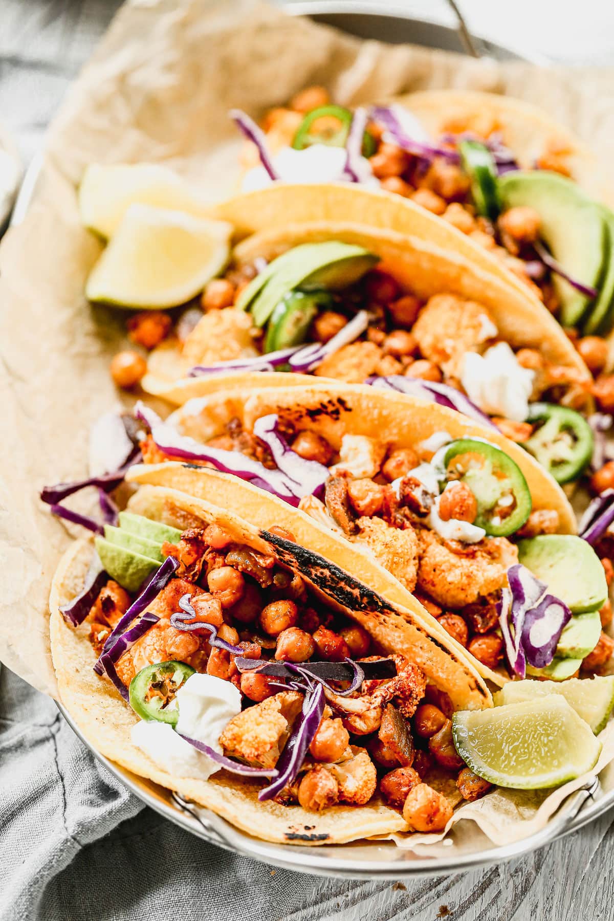 A plate of tasty cauliflower tacos with chickpeas seasoned with jalapeños and red cabbage.