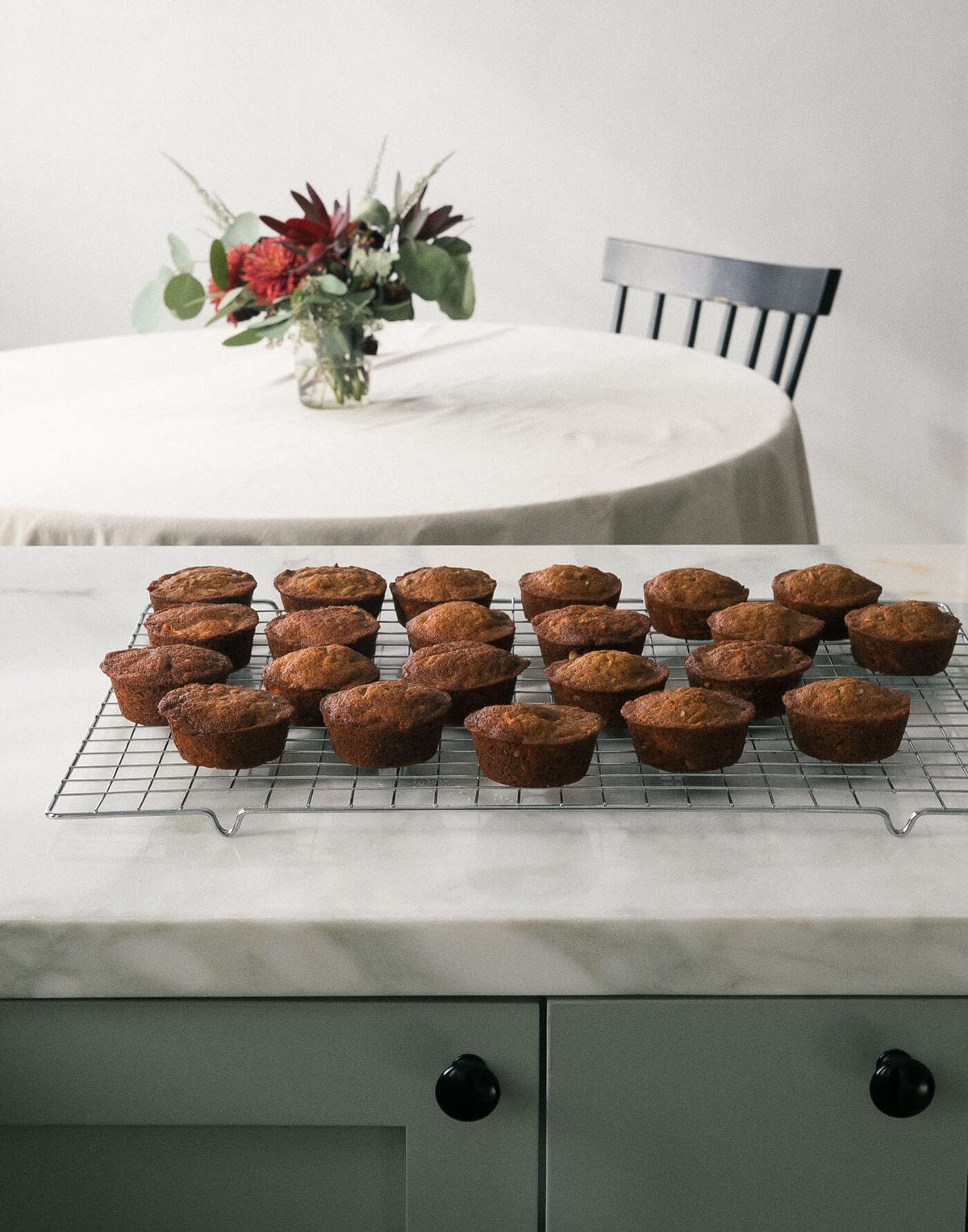 Muffins baked on a wire rack placed on a counter.