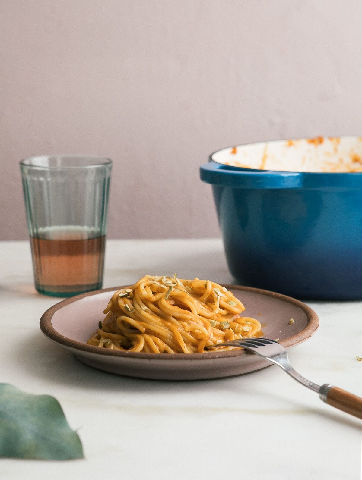 Direct view of pumpkin pasta on a plate with a fork. 