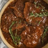 Skillet filled with cubed steaks with balsamic onion sauce