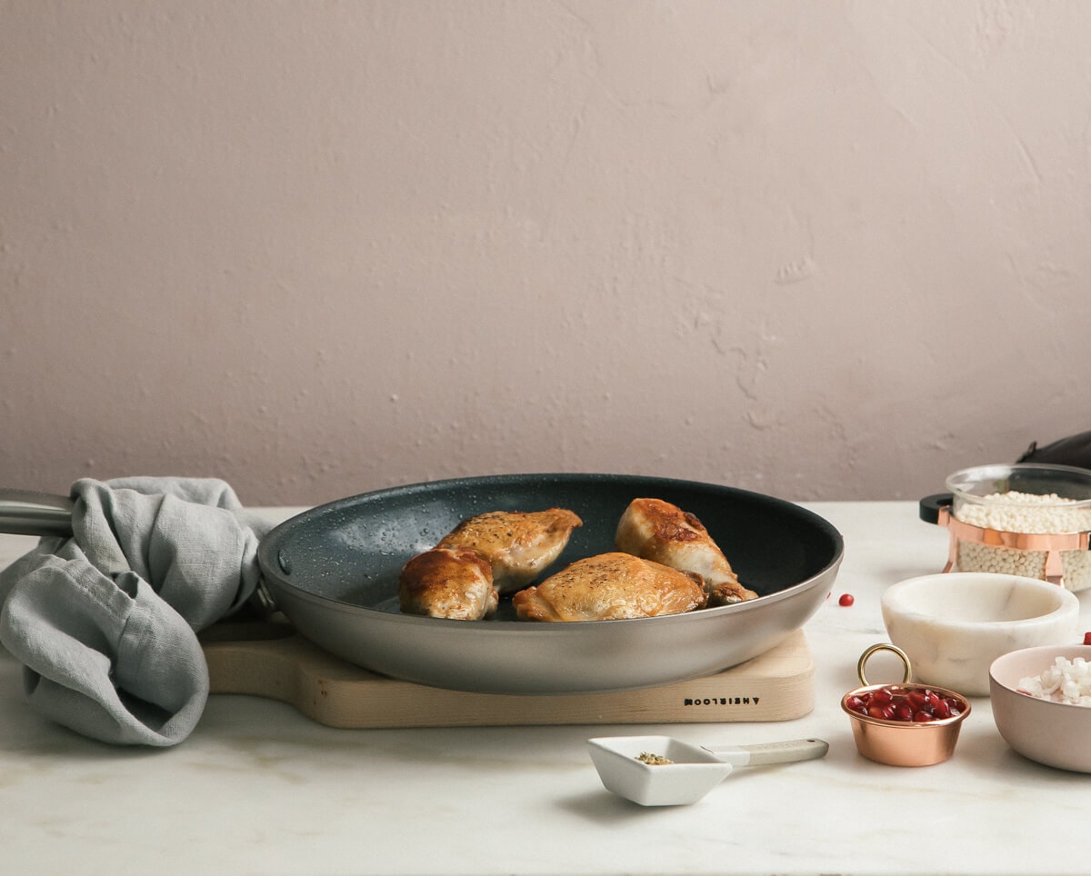 Direct view of browned chicken pieces in a pan.