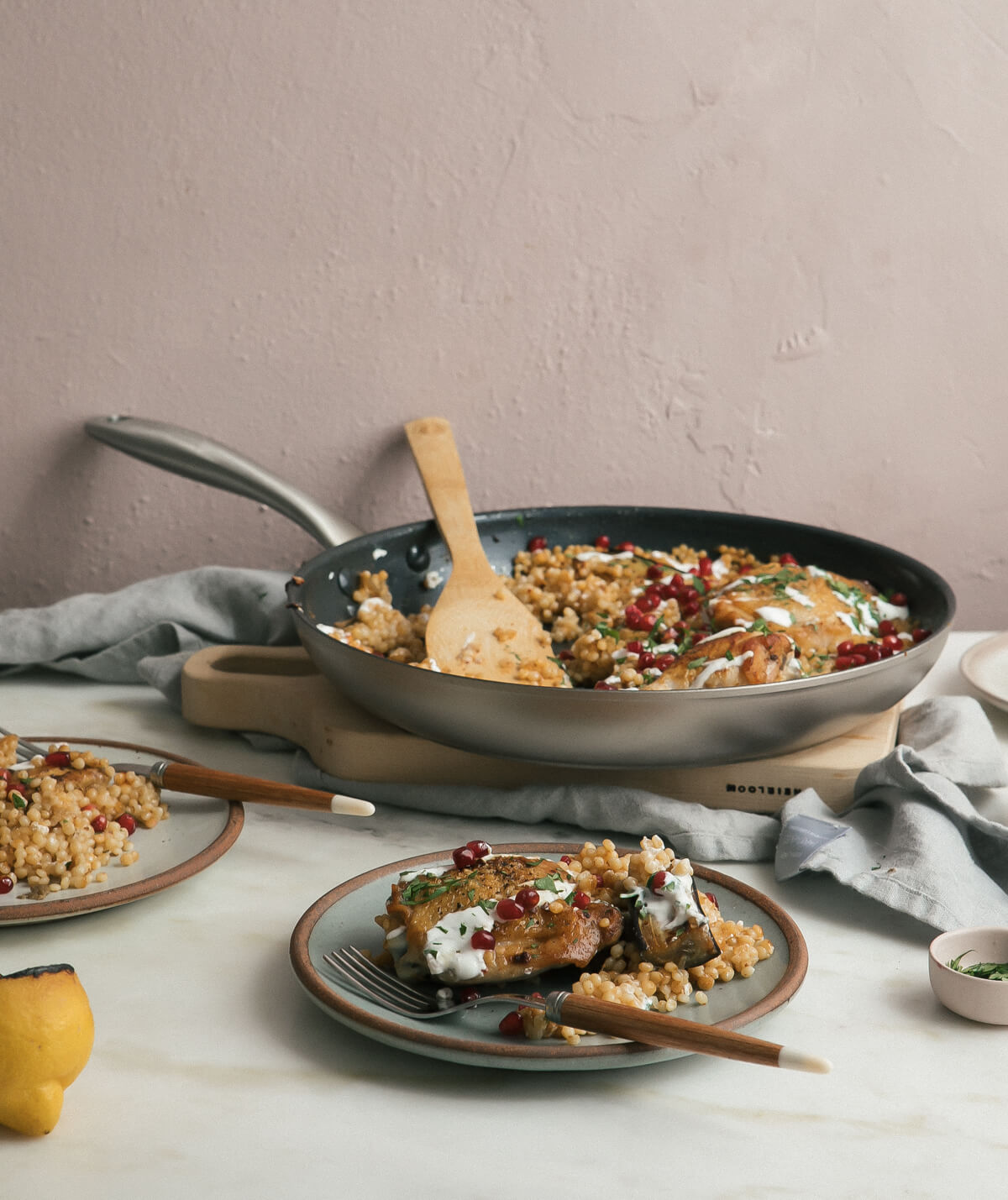 Direct view of harissa chicken couscous on a plate with fork and in a pan.