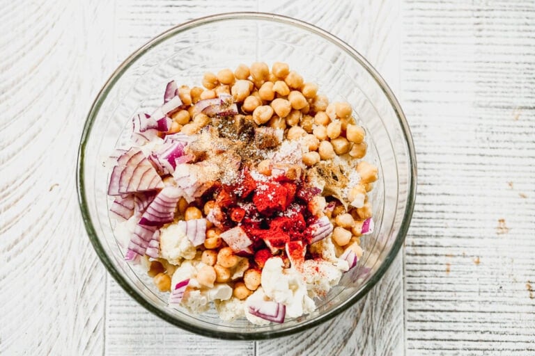 Chickpeas, cauliflower, onion and spices in a glass bowl