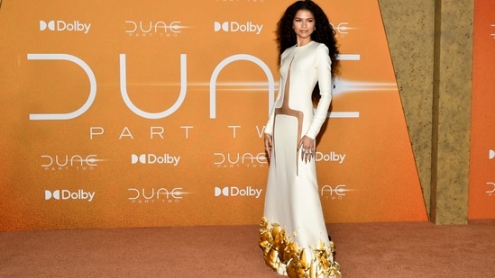 Zendaya turned heads at the premiere of Dune: Part Two in a floor-length white gown with daring cutouts and sculptural gold detailing. She wore her hair in cascading curls and opted for subtle, shimmering makeup. (Evan Agostini/Invision/AP)