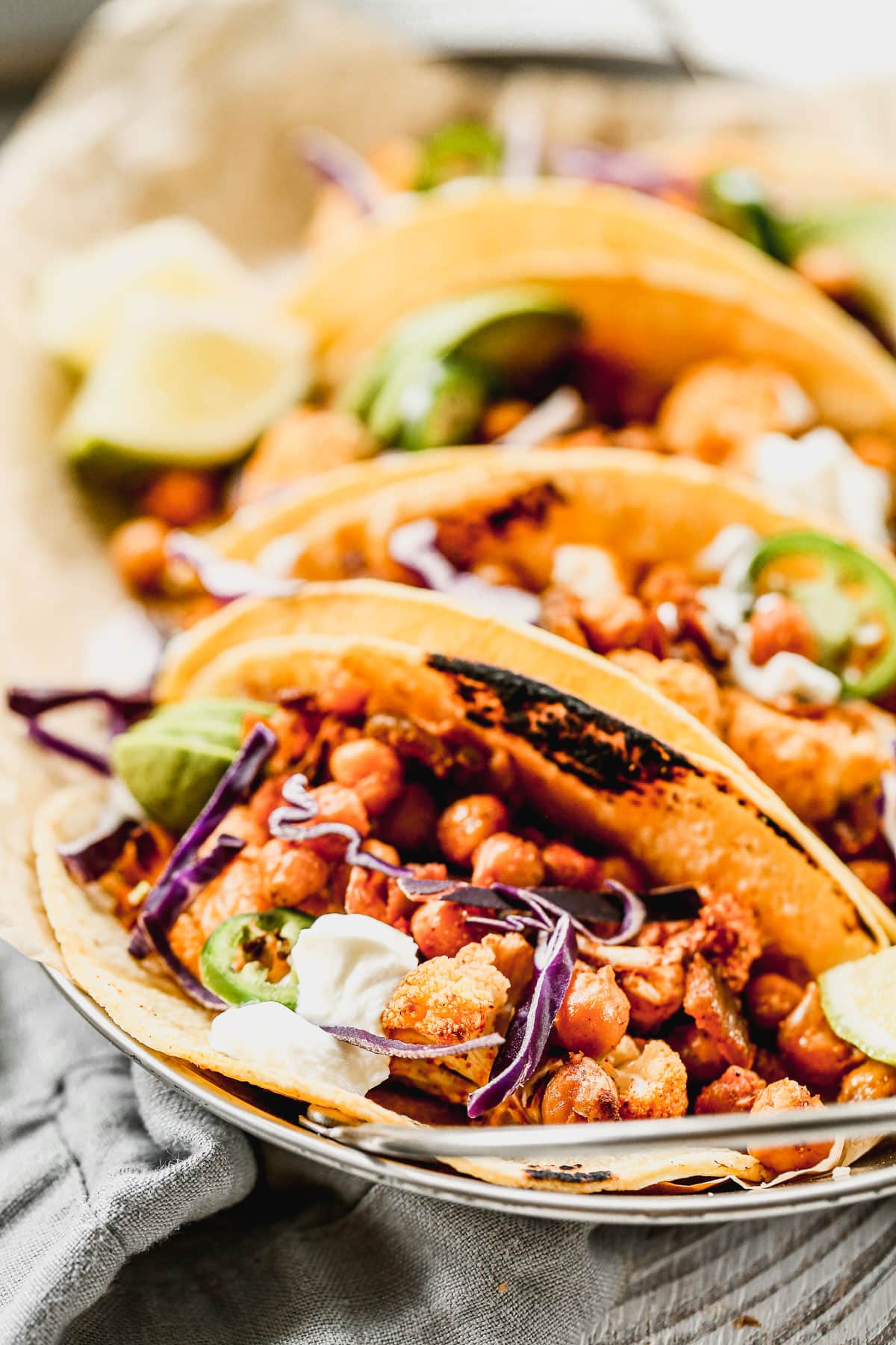 Crispy roasted cauliflower tacos with chickpeas on a white plate