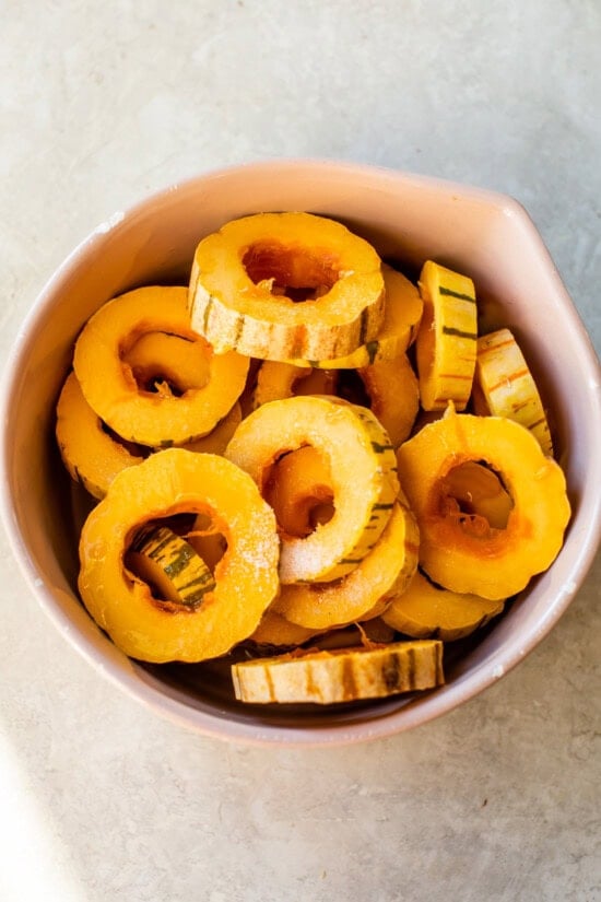 Remove seeds from delicata squash and season.