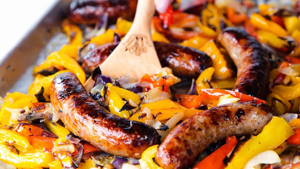 A close up image of Italian sausage and peppers on a baking sheet, ready to serve.