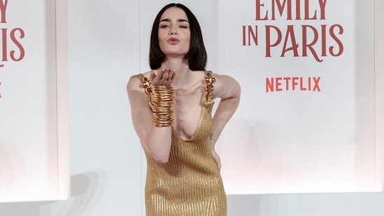 Lily Collins attended the European premiere of Netflix's Emily in Paris season 4 at Rome's Moderno cinema, stunning in a gold knit Schiaparelli dress. She accessorised her look with stacked gold bangles and black high heels. (REUTERS/Remo Casilli)