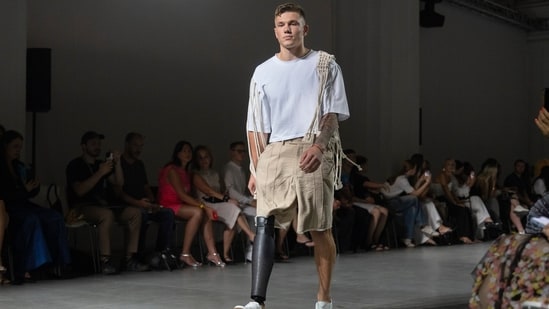 A Ukrainian war veteran wearing a prosthetic limb takes to the catwalk to demonstrate outfits by designers Andreas Moskin and Andriy Bilous. (AP)