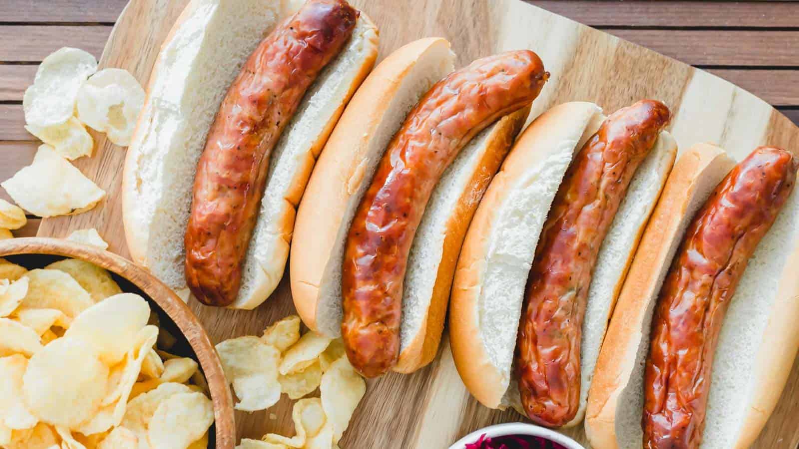 Fried sausages in buns with French fries on the side.