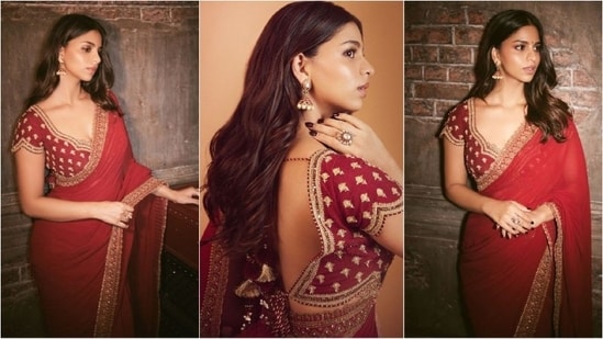 Suhana Khan dazzles in festive style in a stunning red saree by Torani Official. She paired the gorgeous six-yard gown with an embellished blouse featuring a sweetheart neckline and a pair of statement earrings, radiating glamour. (Instagram/@suhanakhan2)