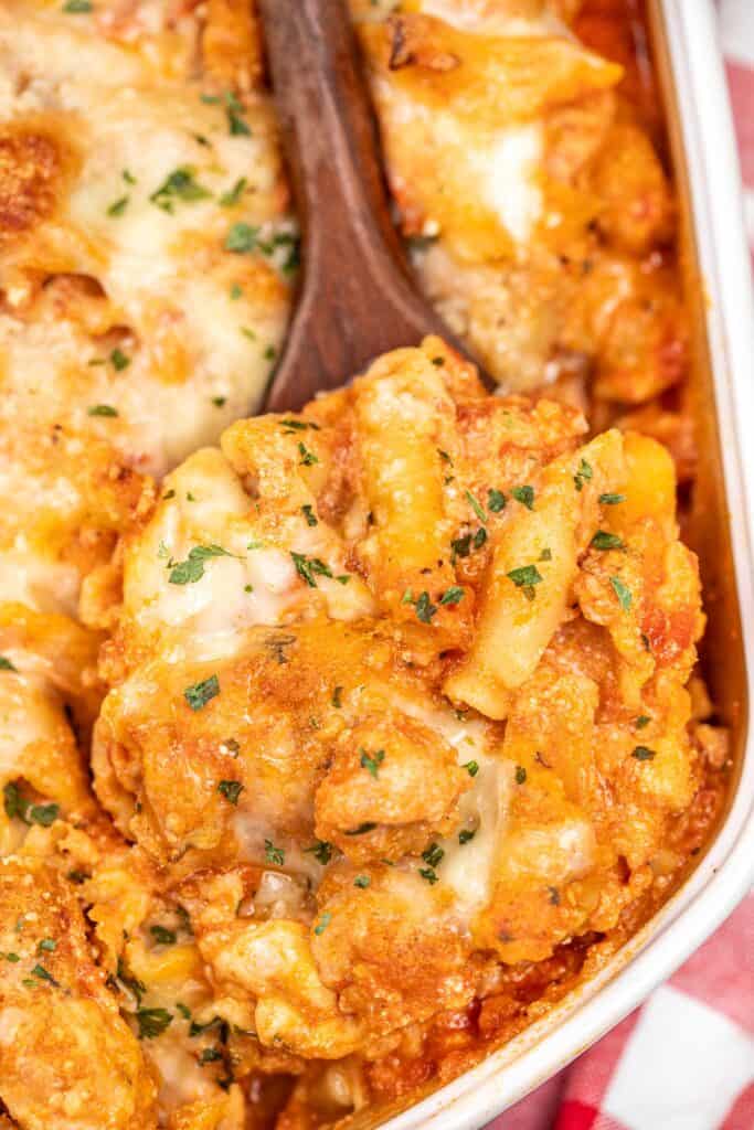 Remove the chicken parmesan pasta casserole from a baking dish