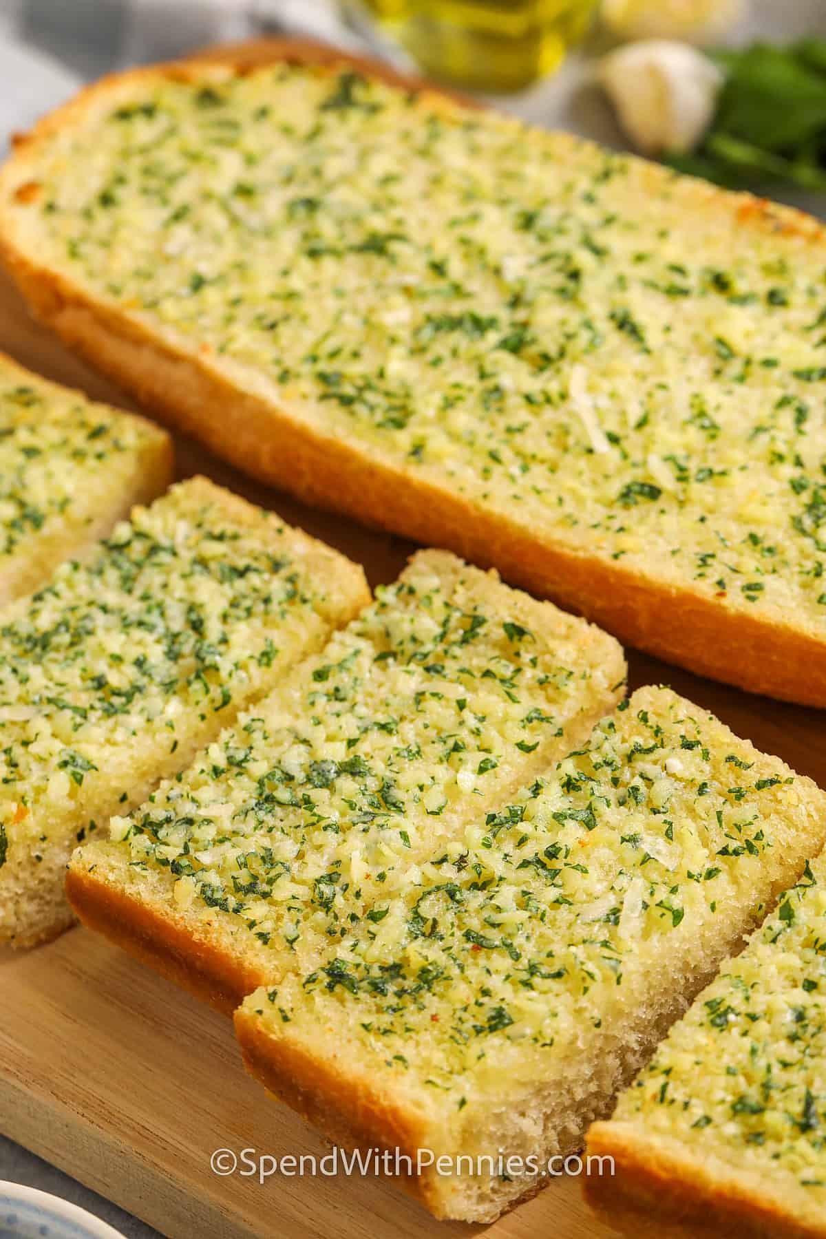 Homemade garlic bread on a cutting board with cut slices