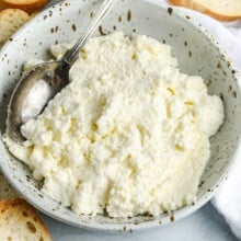 a plate of homemade ricotta cheese alongside crostini