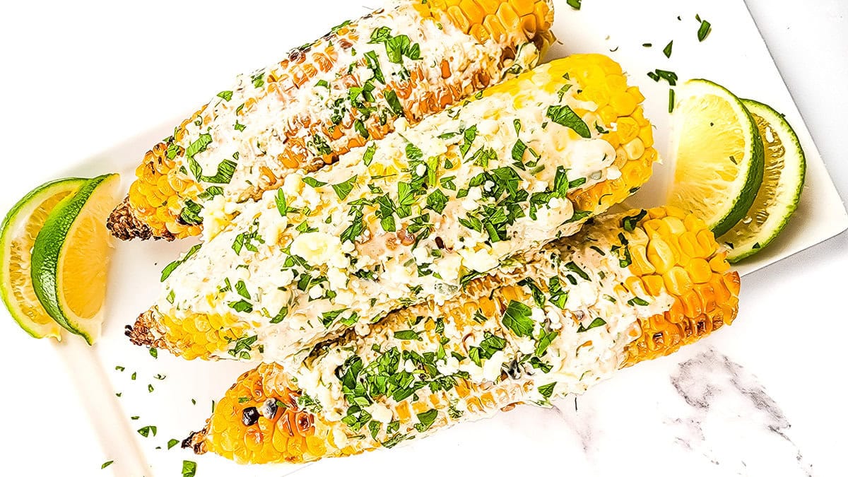 Mexican street corn topped with sour cream sauce and crumbled cheese.