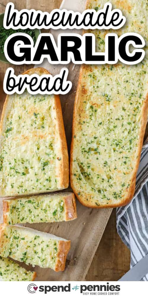 Homemade garlic bread on a wooden board with writing 